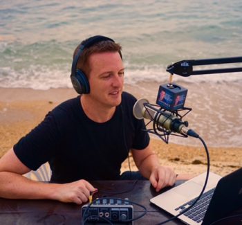 guy doing a podcast by the shore