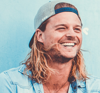 smiling blonde guy with a cap