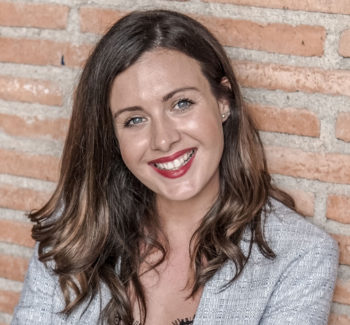 girl smiling with red lipstick brickwall