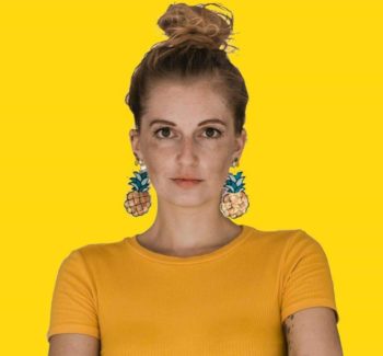 woman wearing big pineapple earrings