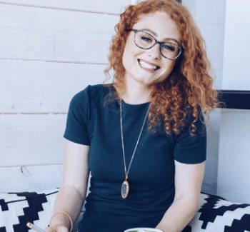 woman with curly red hair sitting on a couch