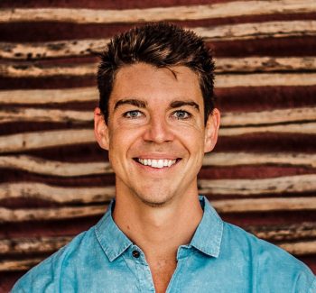 man in a denim shirt smiling