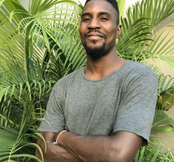man with a plant behind him