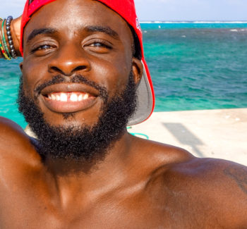 man wearing a red cap at the beach
