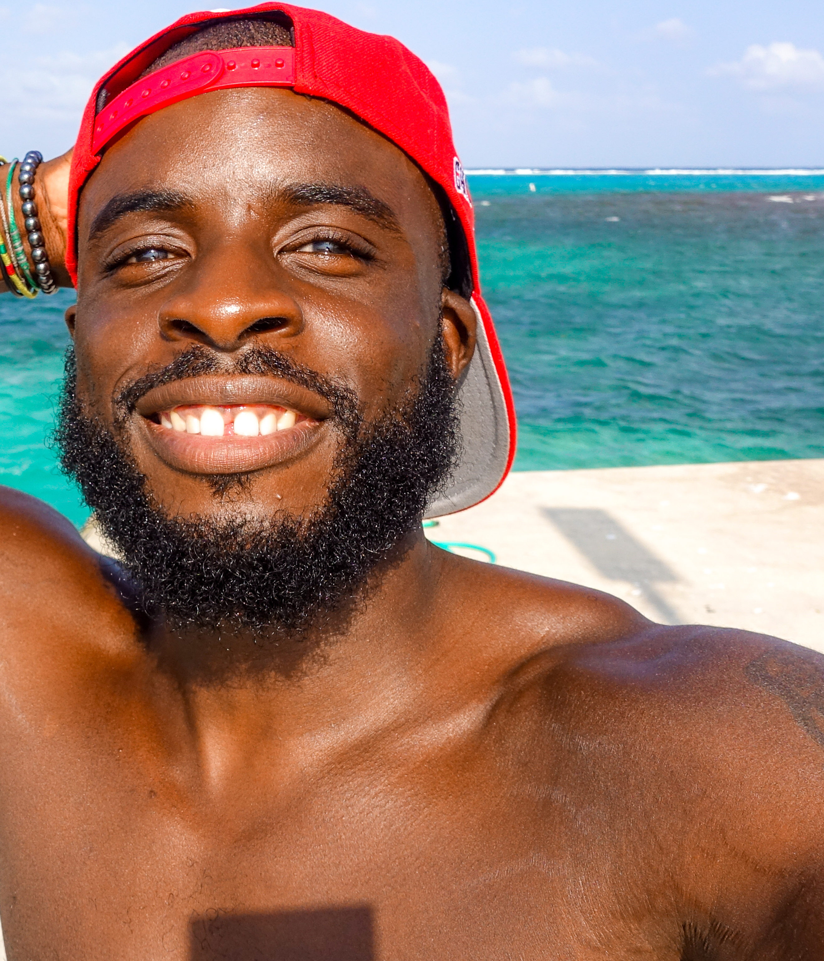 man wearing a red cap at the beach