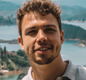 headshot of a man with a scenic background