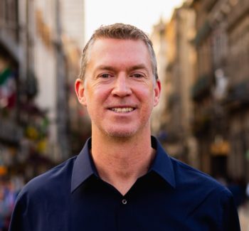 headshot of man wearing navy shirt