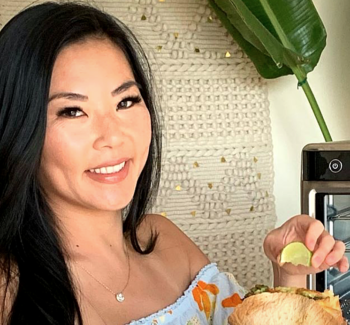 woman holding a slice of lemon