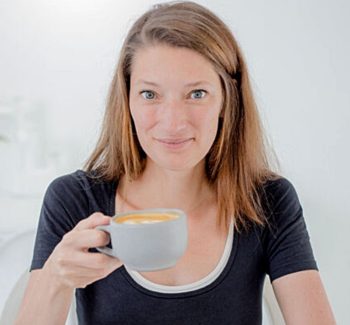 red-haired woman holding a cup of coffee