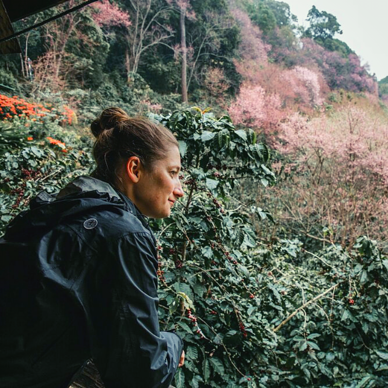 woman standing among lush plants