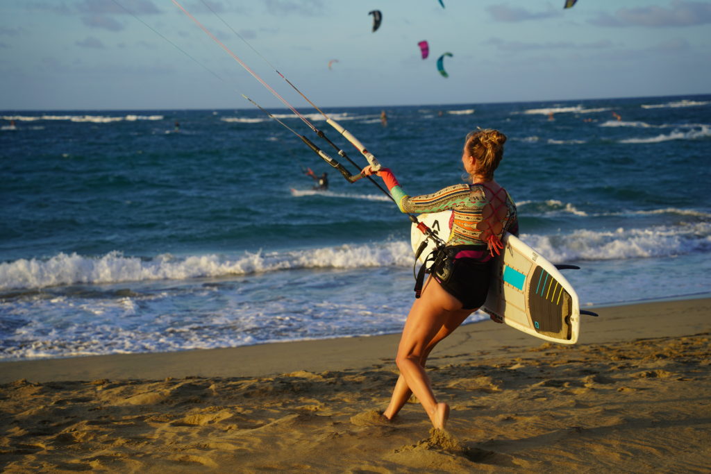 woman on the beach holding a surfboard