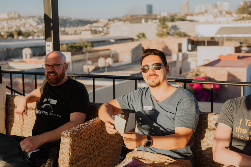 two men sitting on a couch outdoors