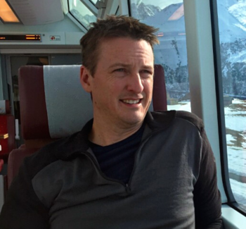 Matt Bowles portrait sitting in a train