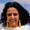 headshot photo of a woman smiling with yellow earrings